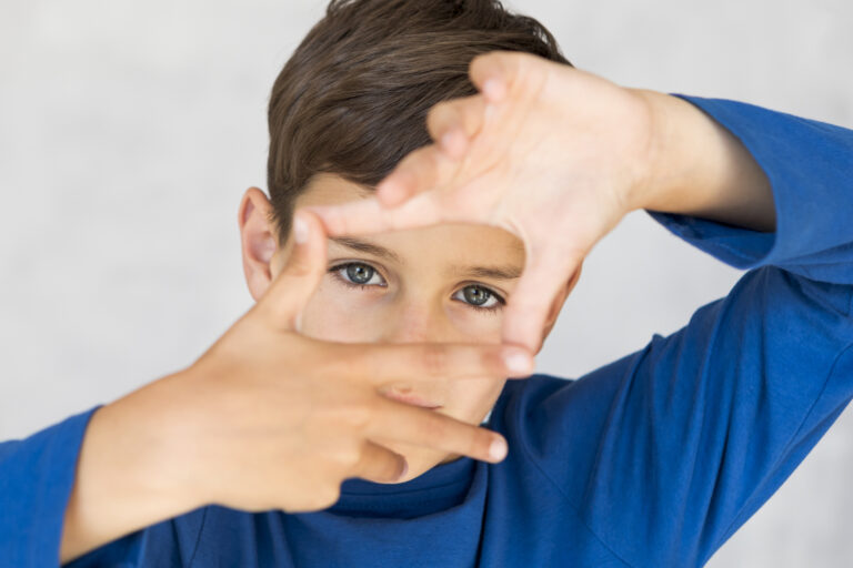 high angle boy making frame with his fingers