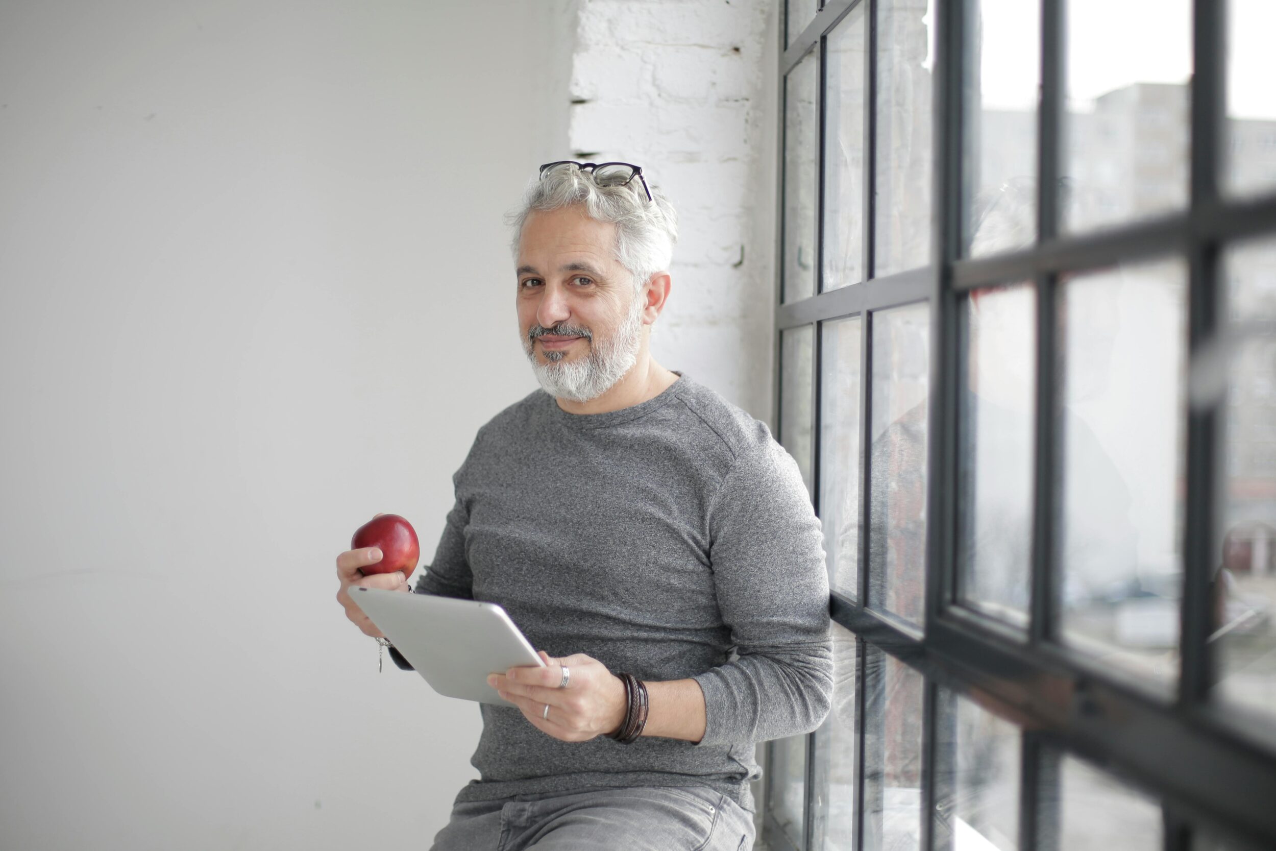 Older man eating an apple with glasses on